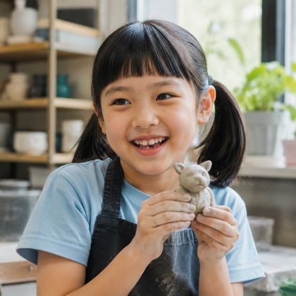 A student holding a clay creation