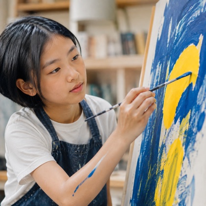 A student painting in blue and yellow